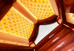 Telhado do castelo inflável coberto decorado como casa de gingerbread no tema gingerbread