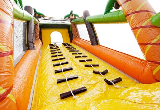 Escalada em um grande castelo inflável de pista de obstáculos