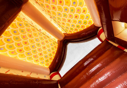 Telhado do castelo inflável coberto decorado como casa de gingerbread no tema gingerbread